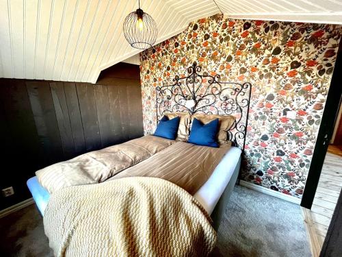 a bed in a room with a floral wall at Cozy house in the countryside in Torestorp
