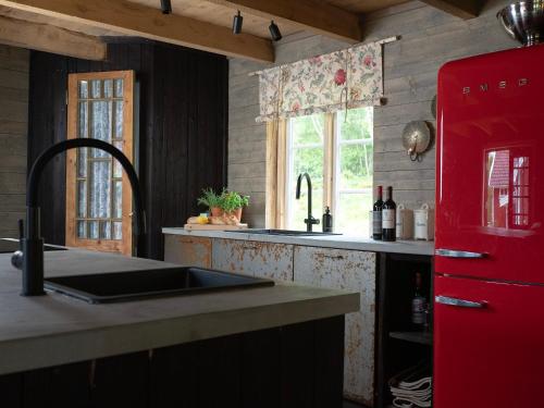 a kitchen with a red refrigerator and a sink at Cozy house in the countryside in Torestorp