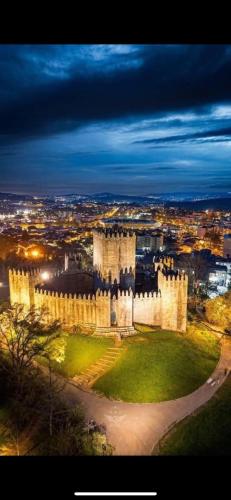 a large white castle with a city in the background at FERREIRA'S HOUSE Guimarães in Guimarães