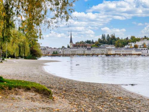 a beach in front of a city with a body of water at ibis budget Hotel Luzern City in Luzern