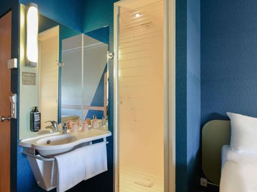 a bathroom with a sink and a mirror at ibis budget Hotel Luzern City in Luzern