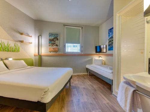a hotel room with a bed and a sink at ibis budget Hotel Luzern City in Luzern
