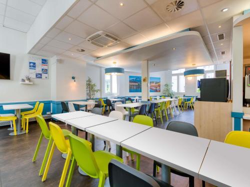 an empty classroom with tables and chairs at ibis budget Hotel Luzern City in Luzern