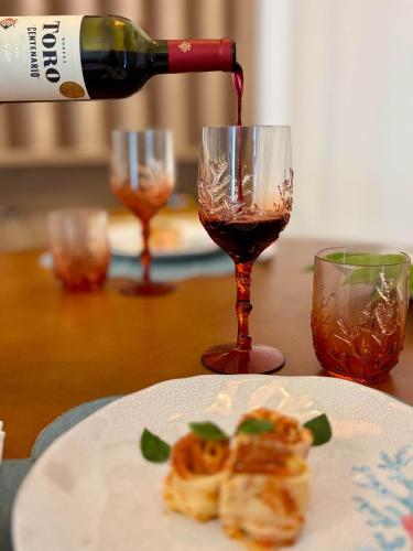a bottle of wine being poured into a wine glass at Villa Naluri - Studio A001 no paraíso Japaratinga! in Japaratinga