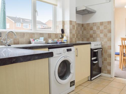 a kitchen with a washing machine and a sink at Bailey's Tavern in Wartnaby