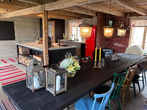 a large wooden table in a room with a kitchen at Cozy house in the countryside in Torestorp