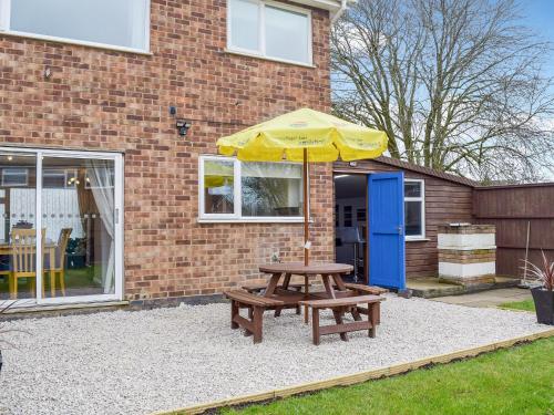 a picnic table with an umbrella in front of a building at Bailey's Tavern in Wartnaby