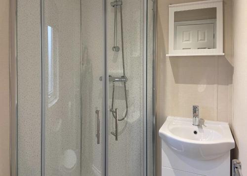 a shower with a glass door next to a sink at Arran Hills in Kilwinning