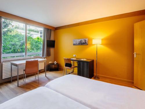 a hotel room with a bed and a desk at Aparthotel Adagio Paris XV in Paris
