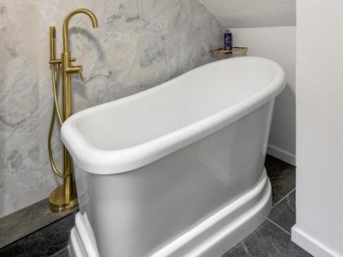 a bathroom with a white toilet with a gold handle at Innish - Uk38783 in Clachan
