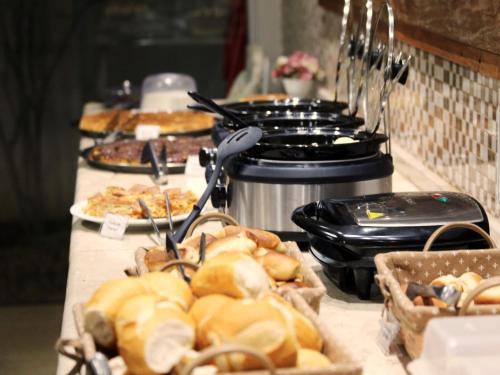 a buffet line with sandwiches and pastries on a table at Hotel Villa Rebellato in Olímpia