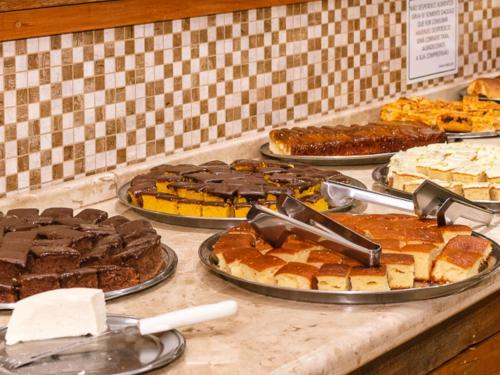 a buffet filled with different types of cakes and pies at Hotel Villa Rebellato in Olímpia