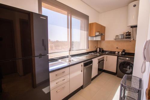 a small kitchen with a sink and a window at confort et détente à Marrakech-Appartement 2 Chambres avec Piscine in Marrakech