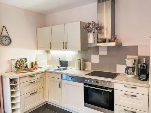 a kitchen with white cabinets and a stove top oven at Apartment Müritz Ferienpark Röbel-32 by Interhome in Marienfelde