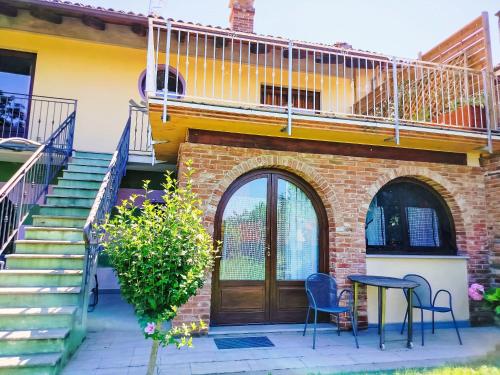 una casa in mattoni con porta in legno, tavolo e sedie di Apartment Il Vino by Interhome a La Morra