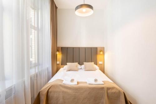 a bedroom with a bed with two towels on it at Hotel Lothus in Wrocław