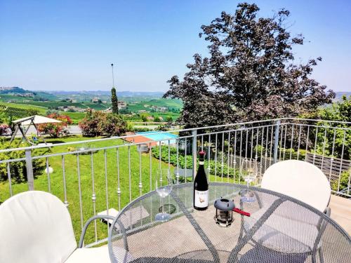 a table with a bottle of wine on a balcony at Apartment Il Sole by Interhome in La Morra