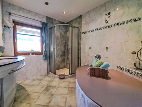 a bathroom with a shower and a tub and a sink at Apartment Berganger by Interhome in Bernau