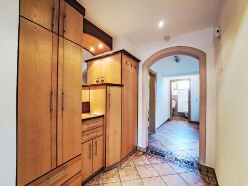 a large kitchen with wooden cabinets and an archway at Apartment Berganger by Interhome in Bernau