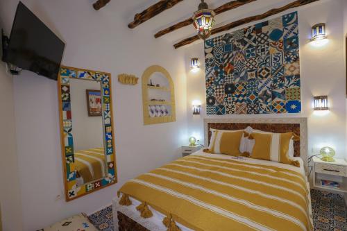 a bedroom with a bed and a painting on the wall at Riad dar HAPPY NOCHE in Essaouira