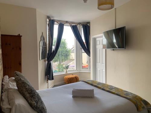 a bedroom with a bed with a television and a window at 155 studio 6 - Uplands - Smart Tv in Swansea