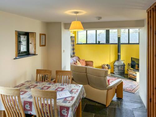 a living room with a table and a fireplace at Ty Nant-Oxl in Gwynfe