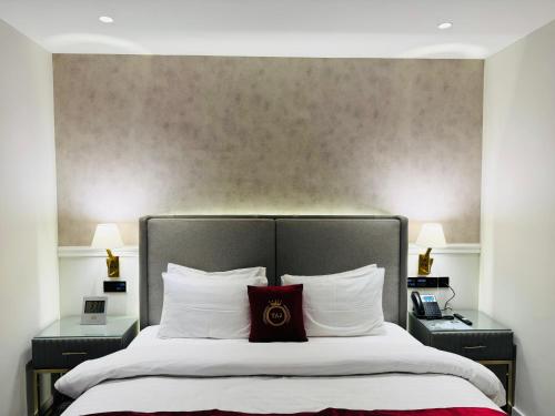 a bedroom with a large bed with two night stands at TAJ Executive Hotel F7 Islamabad in Islamabad