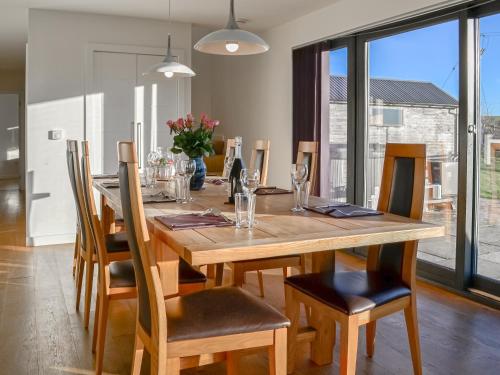 a dining room with a wooden table and chairs at The Longhouse At Threave in Castle Douglas