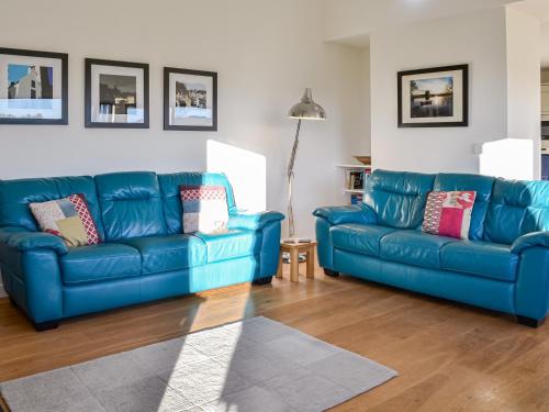 two blue leather couches in a living room at The Longhouse At Threave in Castle Douglas