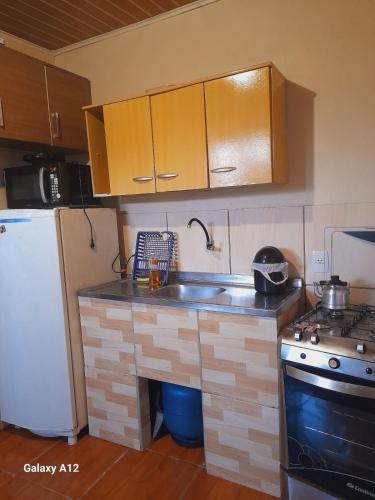 a kitchen with a sink and a refrigerator at Apartamento com 2 quartos suítes em Tramandaí in Tramandaí