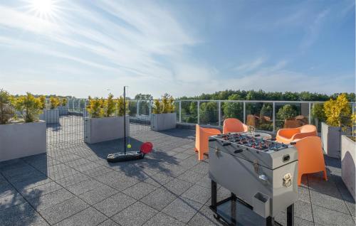 un patio sul tetto con una griglia e sedie arancioni di Gorgeous Apartment In Ustronie Morskie a Sianozety