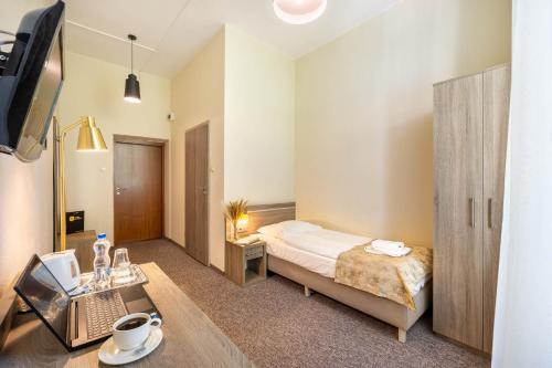 a bedroom with a bed and a desk and a tv at Hotel Lothus in Wrocław