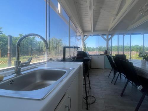 a kitchen with a sink and a large window at Napsugaras Birtok in Röszke