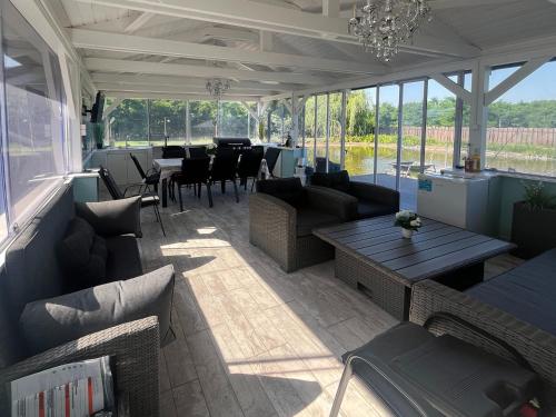 a patio with couches and tables and a dining room at Napsugaras Birtok in Röszke
