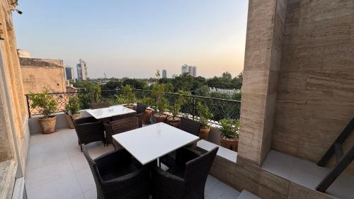 a balcony with tables and chairs and a view of the city at TAJ Executive Hotel F7 Islamabad in Islamabad
