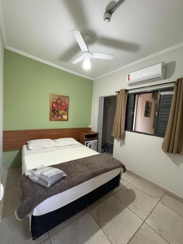 a bedroom with a bed and a ceiling fan at Hotel Rio Branco in Aparecida