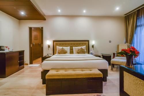 une chambre d'hôtel avec un grand lit et une salle de bain dans l'établissement Royal Studio Golf course road - Gurugram, à Gurgaon