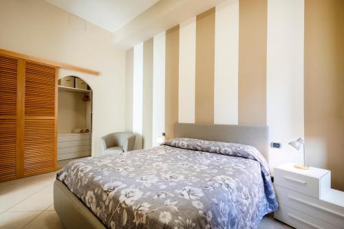 a bedroom with a bed and a striped wall at Martini Matera luxury living in Matera