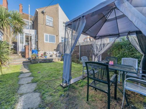 a table and chairs under an umbrella in a yard at Coastal Retreat in Lowestoft