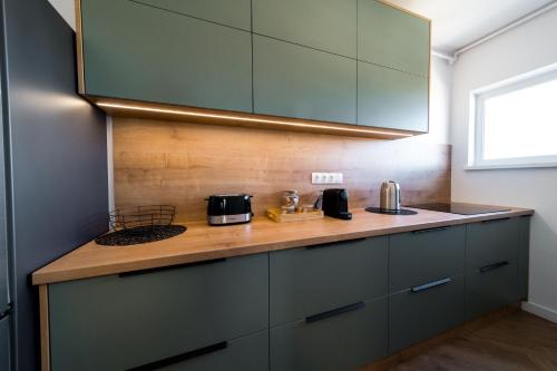 a kitchen with green cabinets and a counter top at Sky9 Apartment in Odorheiu Secuiesc