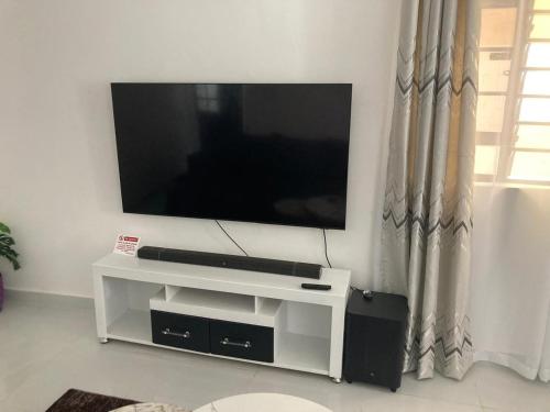 a flat screen tv sitting on top of a white entertainment center at Pamito Sunny Paradise in Diani in Diani Beach