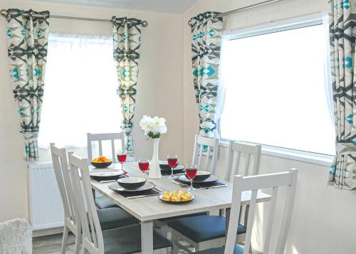 a dining room table and chairs with wine glasses and flowers at Springhouse Country Park in Slaley