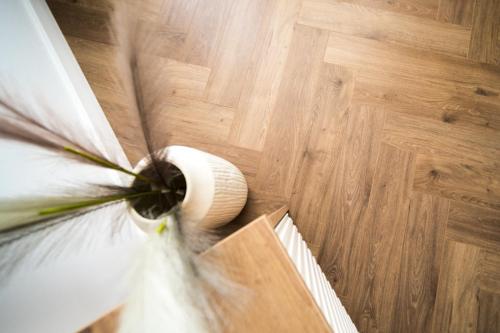 a close up of a flower on a wooden floor at Sky9 Apartment in Odorheiu Secuiesc
