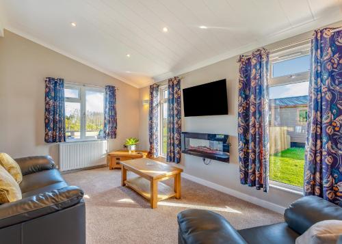 a living room with a couch and a tv at Beaconsfield Park in Shrewsbury
