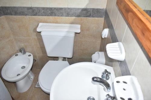 a bathroom with a white toilet and a sink at Apart Piedra Libre in Tandil