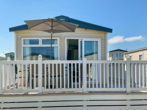 a house with a white fence and an umbrella at Seaside Jollys in Blue Anchor