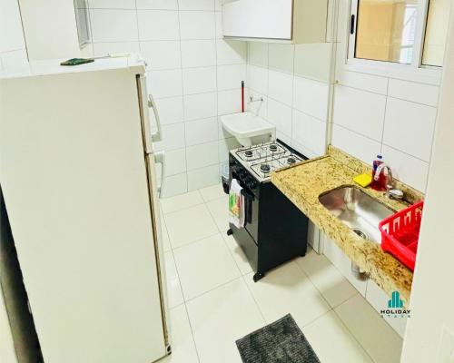 a small kitchen with a stove and a sink at Brisa do Mar Apartments in Fortaleza