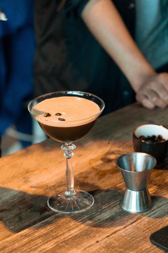 a drink in a martini glass on a wooden table at The Social Hub Rotterdam Extended Stay in Rotterdam