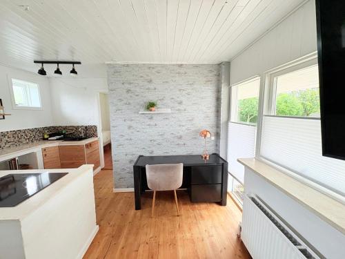 a kitchen with a table with a chair in it at Lejlighed Edelweiss in Svendborg