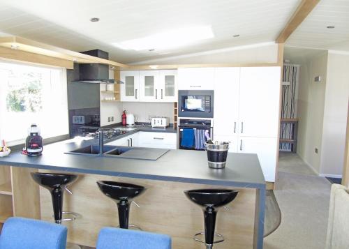 a kitchen with a large island with blue bar stools at Fir Trees in Chester